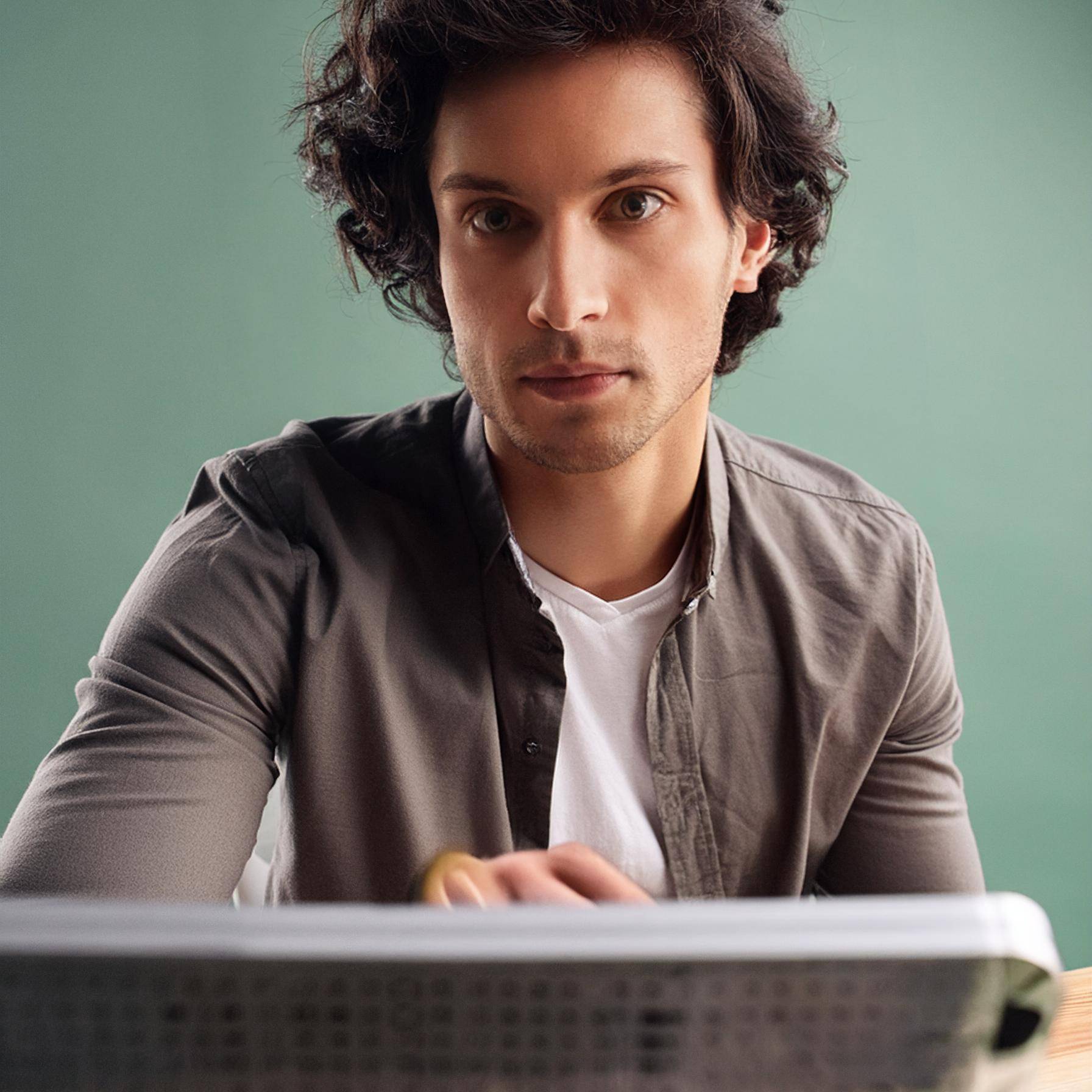 Firefly-Ritratto-digitale-di-un-designer-maschio-metre-lavora-al-iMac-capelli-ricci-obiettivo-35mm-1-uai-1792x1792